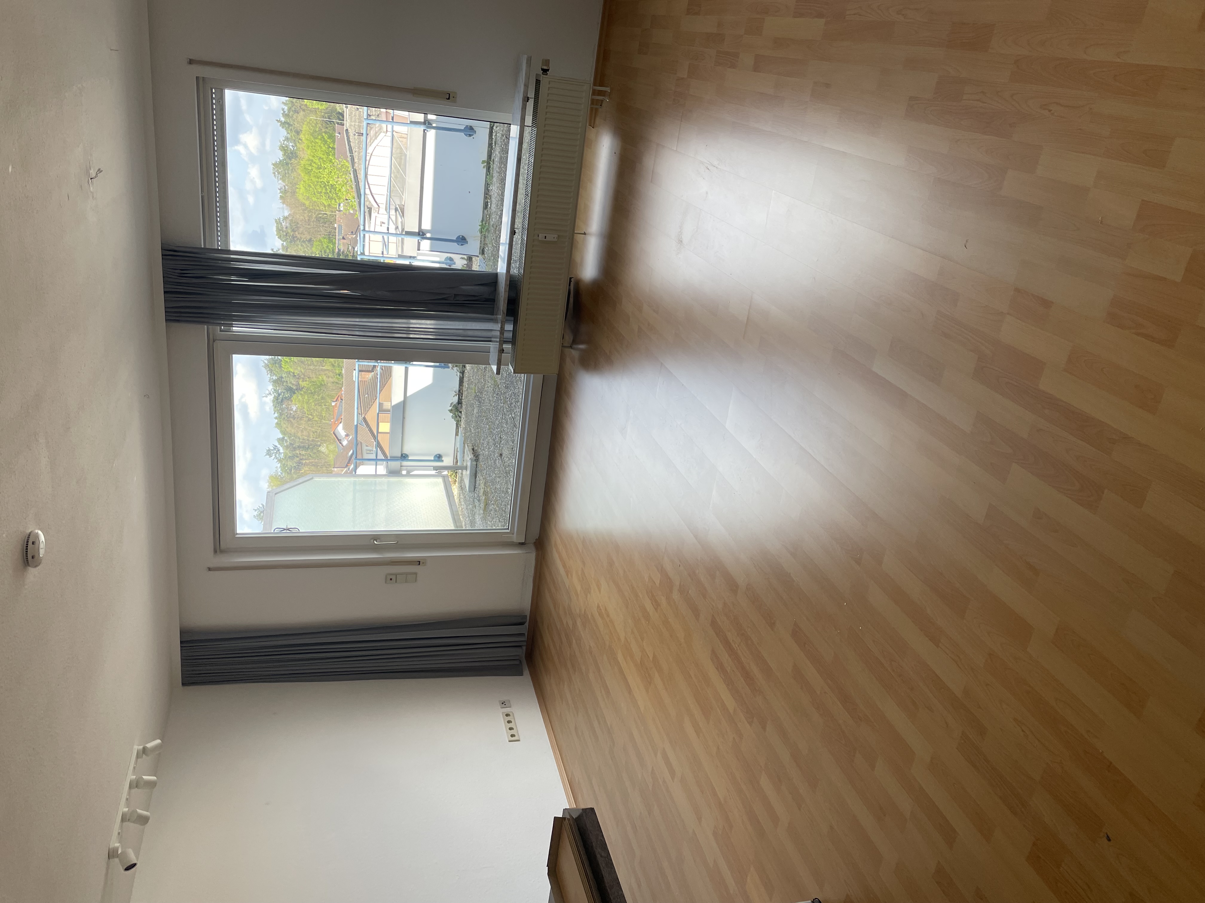 Heller Wohnraum mit Laminatboden und großer Fensterfront